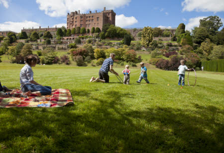 Family playing in the garden at Powis Castle, Powys, Wales.