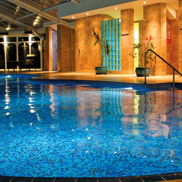 Indoor pool lit up at night - Metropole Hotel & Spa, Llandrindod Wells