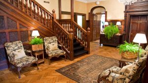 Grand entrance hall with sweeping staircase - Rowton Hall Hotel & Spa, Chester