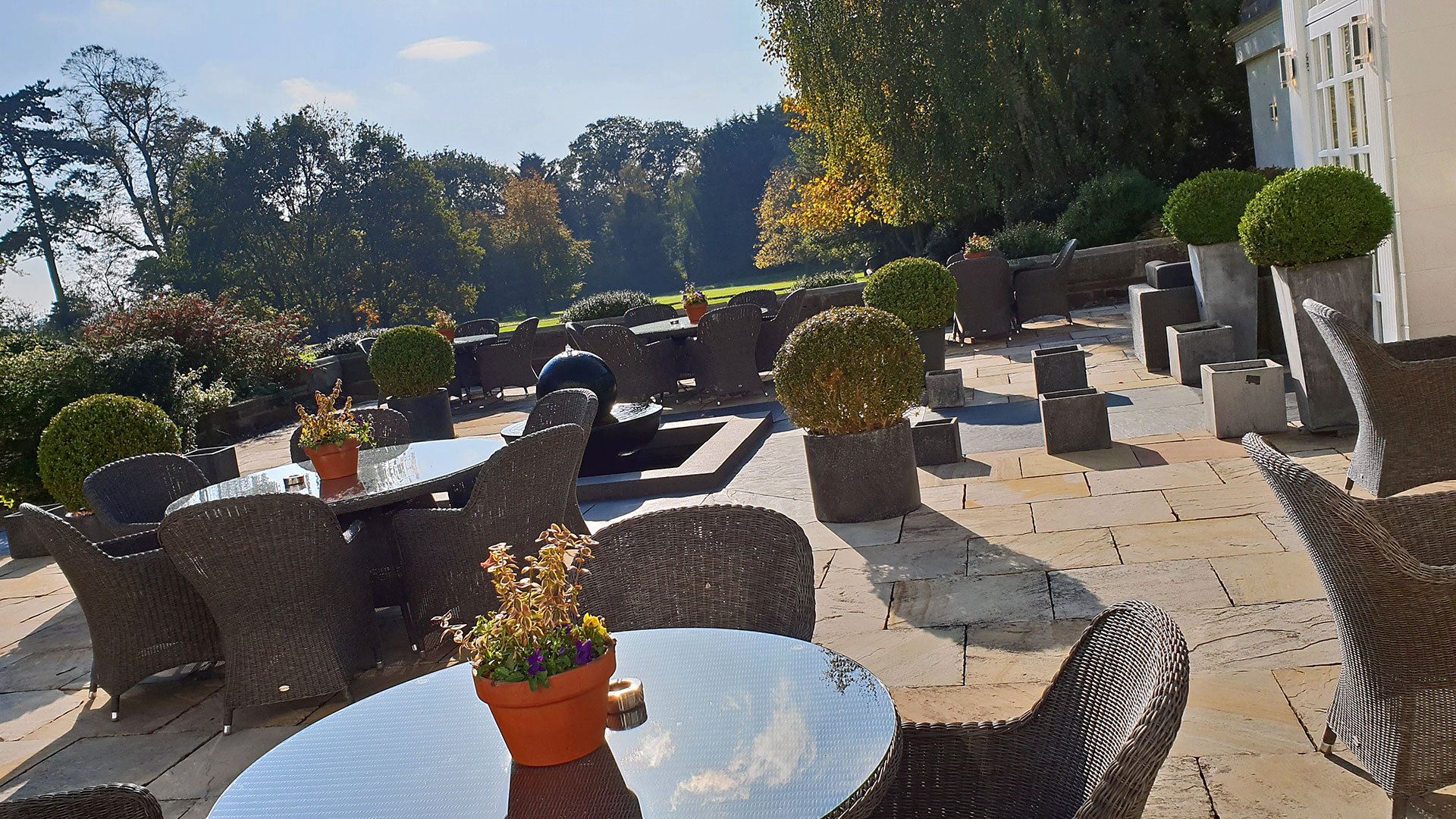 The terrace overlooking the grounds in the sunshine - Rowton Hall Hotel, Chester