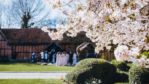 Cherry blossoms and the bridal party outside Tithe Barn - Barns Hotel, Bedford