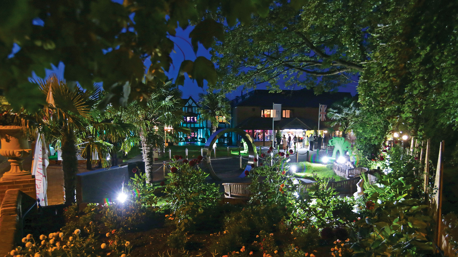 Peeking through lush foliage and the sculpture garden towards the hotel - Donnington Manor Hotel, Sevenoaks