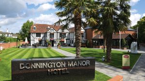 The hotel exterior with palm trees by day - Donnington Manor Hotel, Sevenoaks