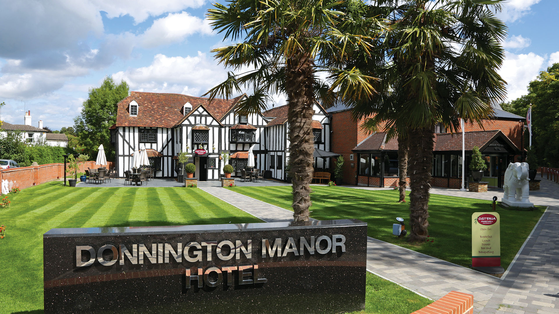 The hotel exterior with palm trees by day - Donnington Manor Hotel, Sevenoaks