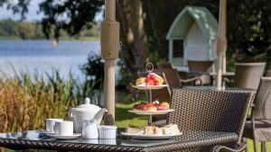 Afternoon tea served on the lawn overlooking the pond - Frensham Pond Country House Hotel & Spa, Farnham