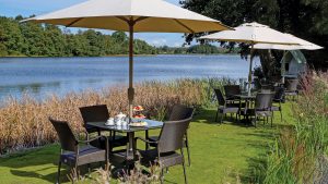 Afternoon tea served on the lawn overlooking the pond - Frensham Pond Country House Hotel & Spa, Farnham