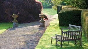 Two benches next to a path in the mature gardens - Gliffaes Country House Hotel, Brecon Beacons