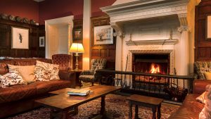 Wood burning fire with cosy seating in the decadent lounge - Gliffaes Country House Hotel, Brecon Beacons