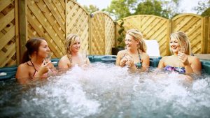 Ladies enjoying outdoor hot tub with a glass of Champagne - Hintlesham Hall Hotel, Ipswich