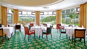 The restaurant set for dinner with panoramic views of Dartmoor - Ilsington Country House Hotel & Spa, Dartmoor