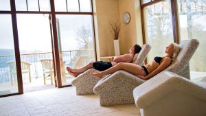 A couple enjoying the heated loungers and give over the lake - Lake Vyrnwy Hotel & Spa, Snowdonia