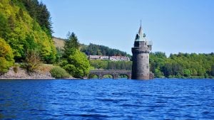The hotel on a hill above the lake and straining tower - Lake Vyrnwy Hotel & Spa, Snowdonia