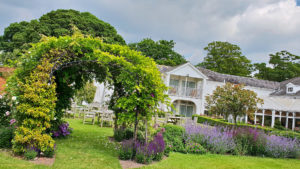 The gardens of the hotel with outside seating area on the lawn - Rowton Hall Hotel, Chester