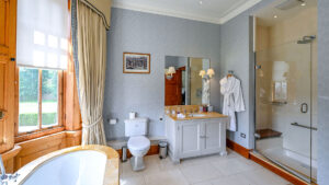 Spacious deluxe double bathroom at The Jockey Club, Newmarket, with luxury amenities.
