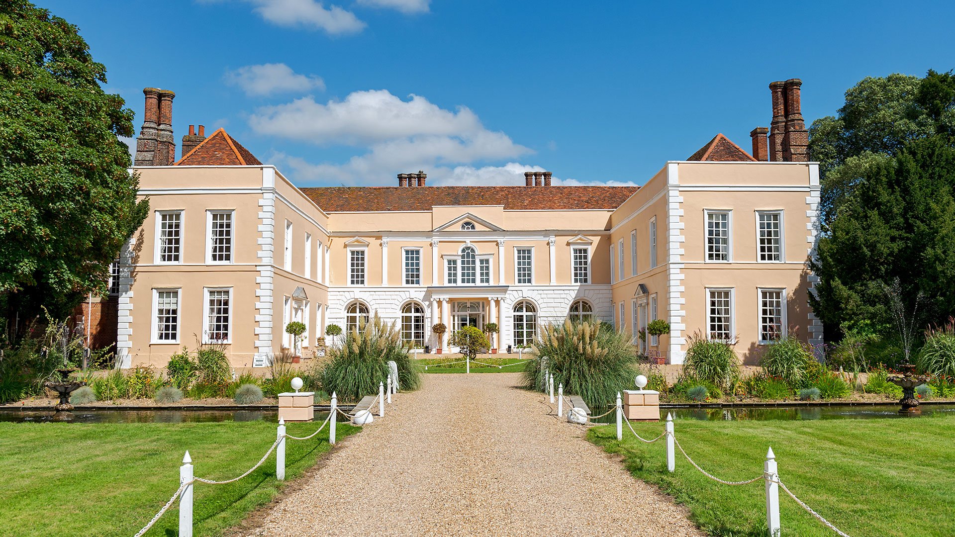 Exterior view of Hintlesham Hall Hotel in Suffolk, showcasing its historic architecture and picturesque surroundings - Classic British Hotels